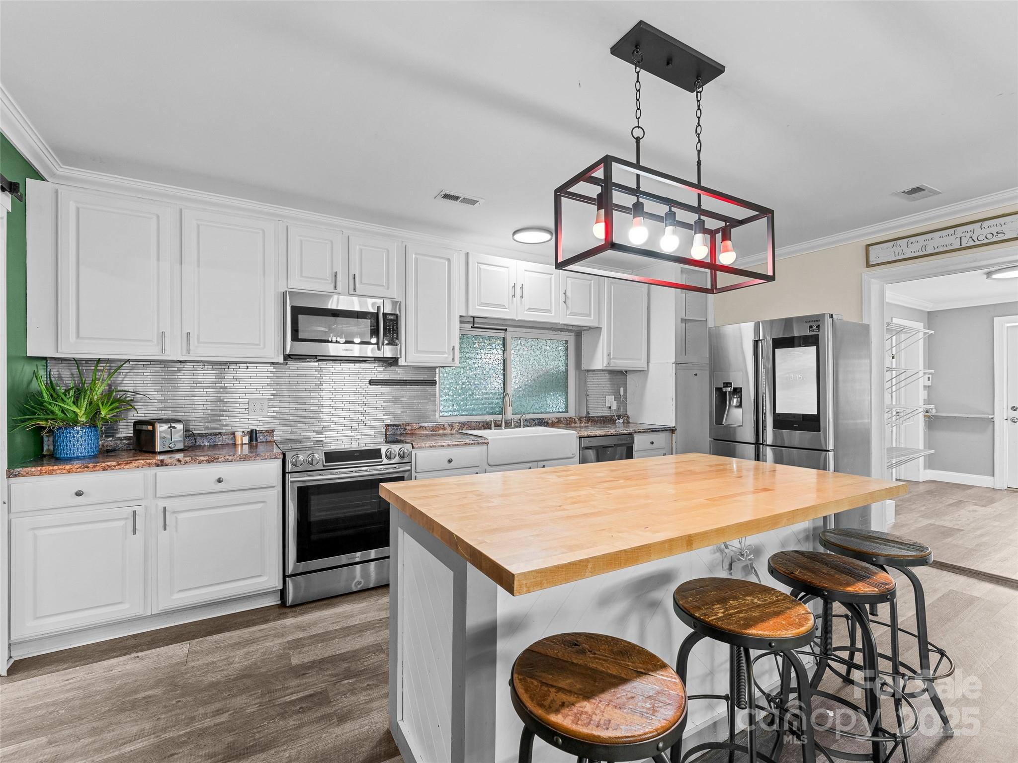 1148 North Ridge Road Hendersonville, NC 28792 - Photo 7 of 42 a kitchen with sink a stove and chairs with wooden floor