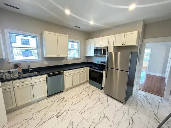 a kitchen with granite countertop a refrigerator and a sink