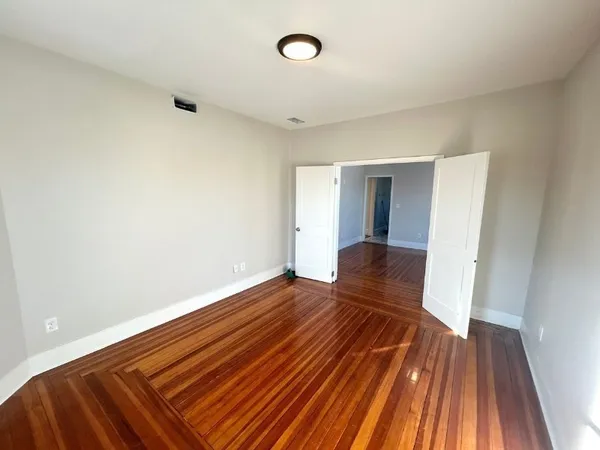 a view of an empty room with wooden floor