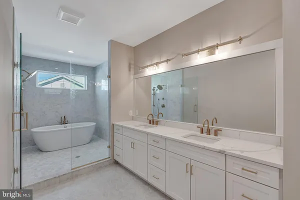 a bathroom with a double vanity sink mirror and bathtub