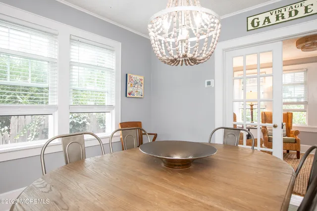 a view of a dining room with furniture a chandelier and wooden floor