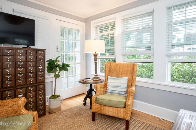 a living room with furniture a flat screen tv and a floor to ceiling window
