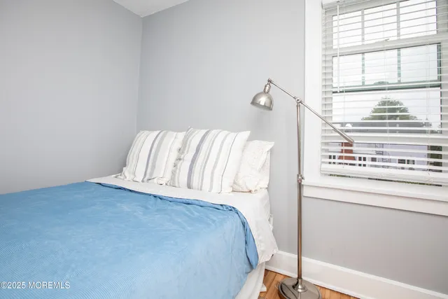 a view of a bedroom with wooden floor and a window
