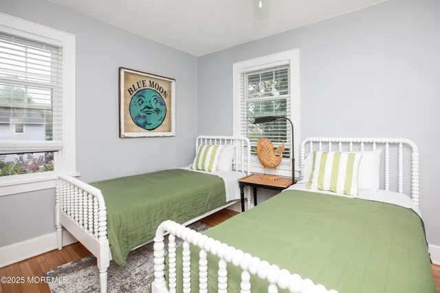 a bedroom with two beds and a large window