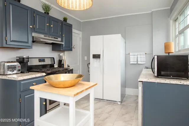 a kitchen with stainless steel appliances granite countertop a sink a stove and a refrigerator