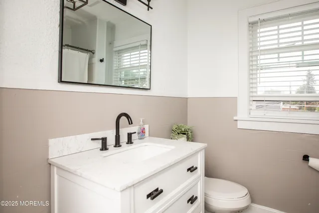 a bathroom with a toilet sink and mirror