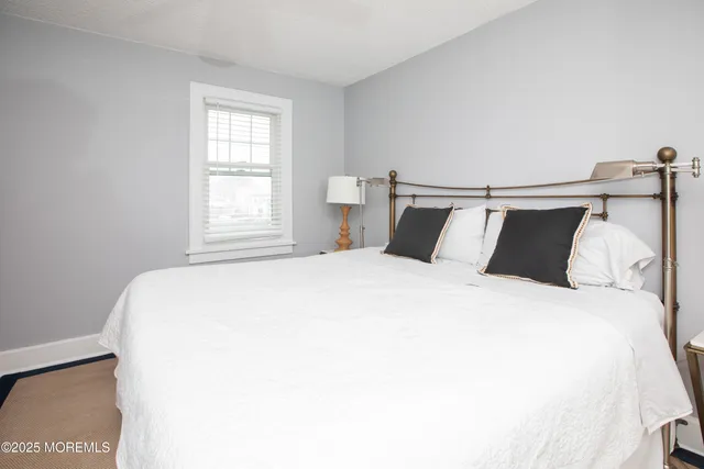 a large bed sitting in a bedroom next to a window