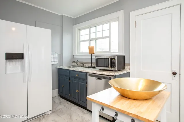 a kitchen with a sink a microwave and refrigerator