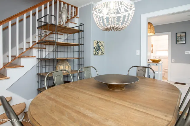 a bedroom with a bed a chandelier and a chair