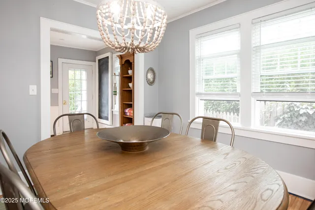 a dining room with furniture a chandelier and window