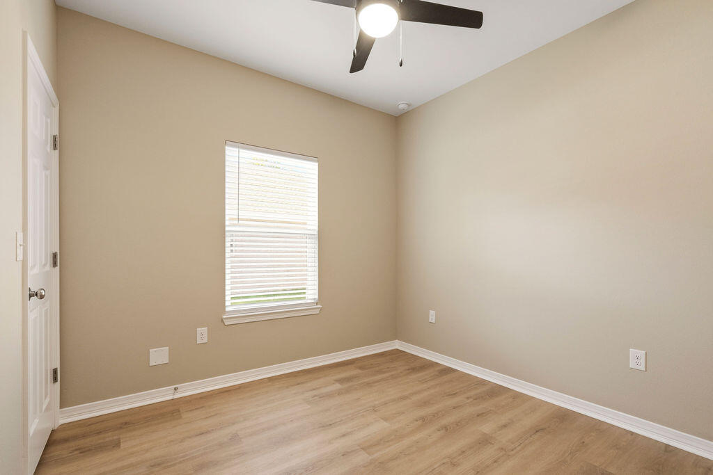3810 Golden Acres Circle Crestview, FL 32539 - Photo 8 of 9 an empty room with wooden floor and windows