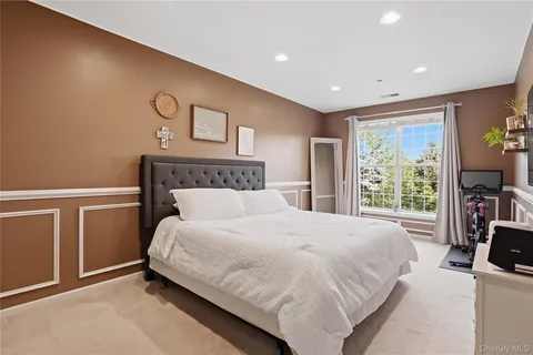 a bedroom with a large bed and a flat tv screen