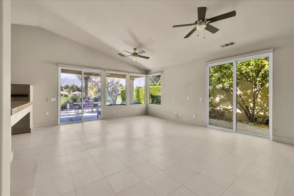 an empty room with a ceiling fan and window