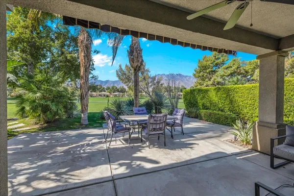 a view of a patio with table and chairs with wooden floor and fence