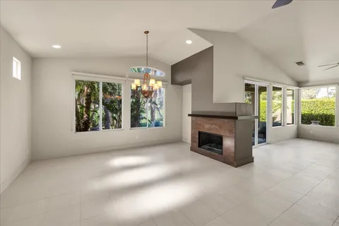 a view of an empty room with window and fire place