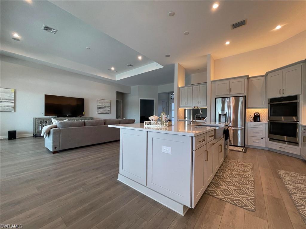 15587 Montello Lane Naples, FL 34114 - Photo 16 of 17 a large kitchen with cabinets and flat screen tv