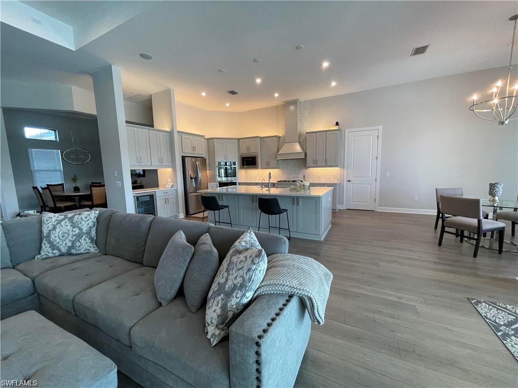 15587 Montello Lane Naples, FL 34114 - Photo 2 of 17 a living room with furniture and kitchen view