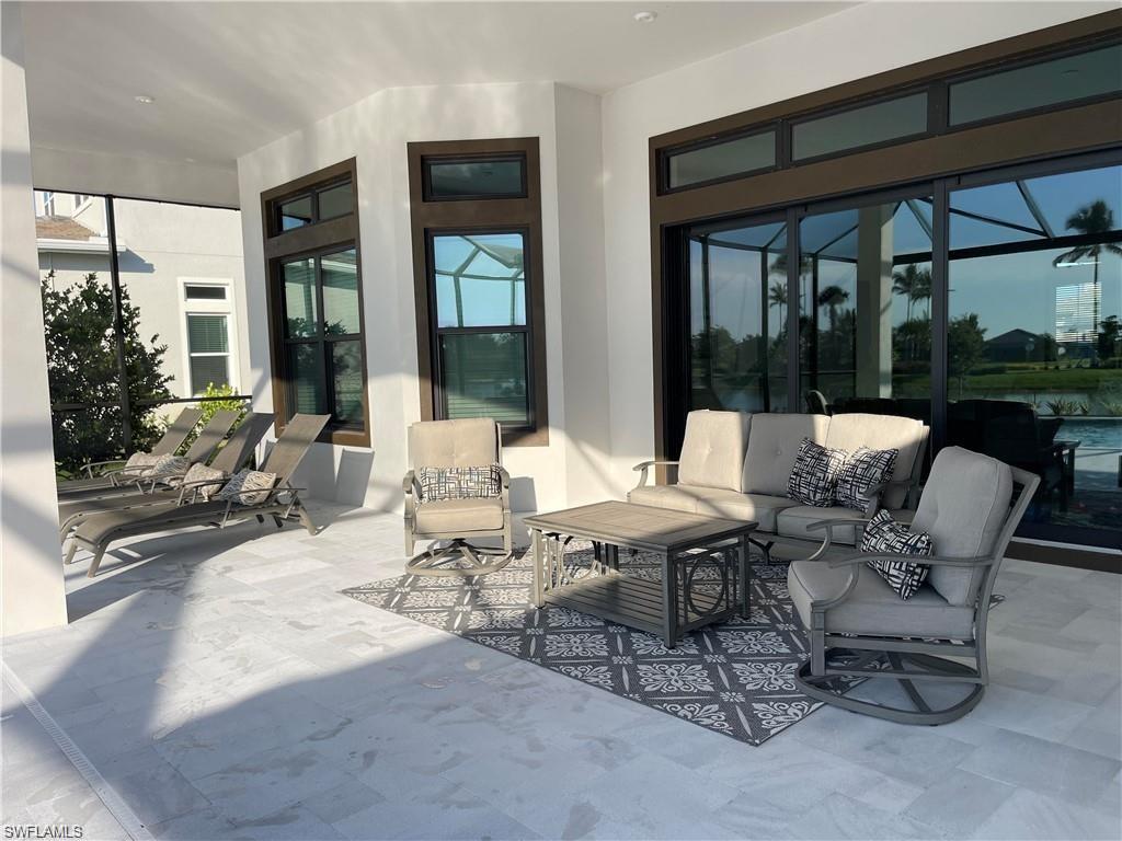 15587 Montello Lane Naples, FL 34114 - Photo 3 of 17 a living room with patio furniture and floor to ceiling windows