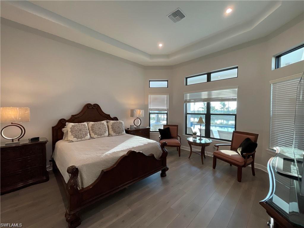 15587 Montello Lane Naples, FL 34114 - Photo 5 of 17 a bedroom with a bed a couch and a window