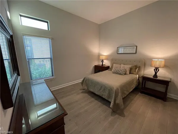 a bedroom with a bed window and a night stand
