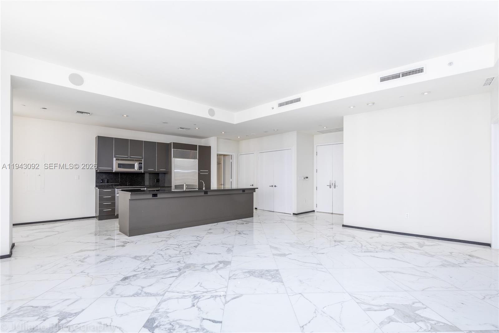 901 Brickell Key Boulevard, Unit 3407 Miami, FL 33131 - Photo 4 of 44 a large kitchen with a stove a sink dishwasher and a refrigerator with wooden floor