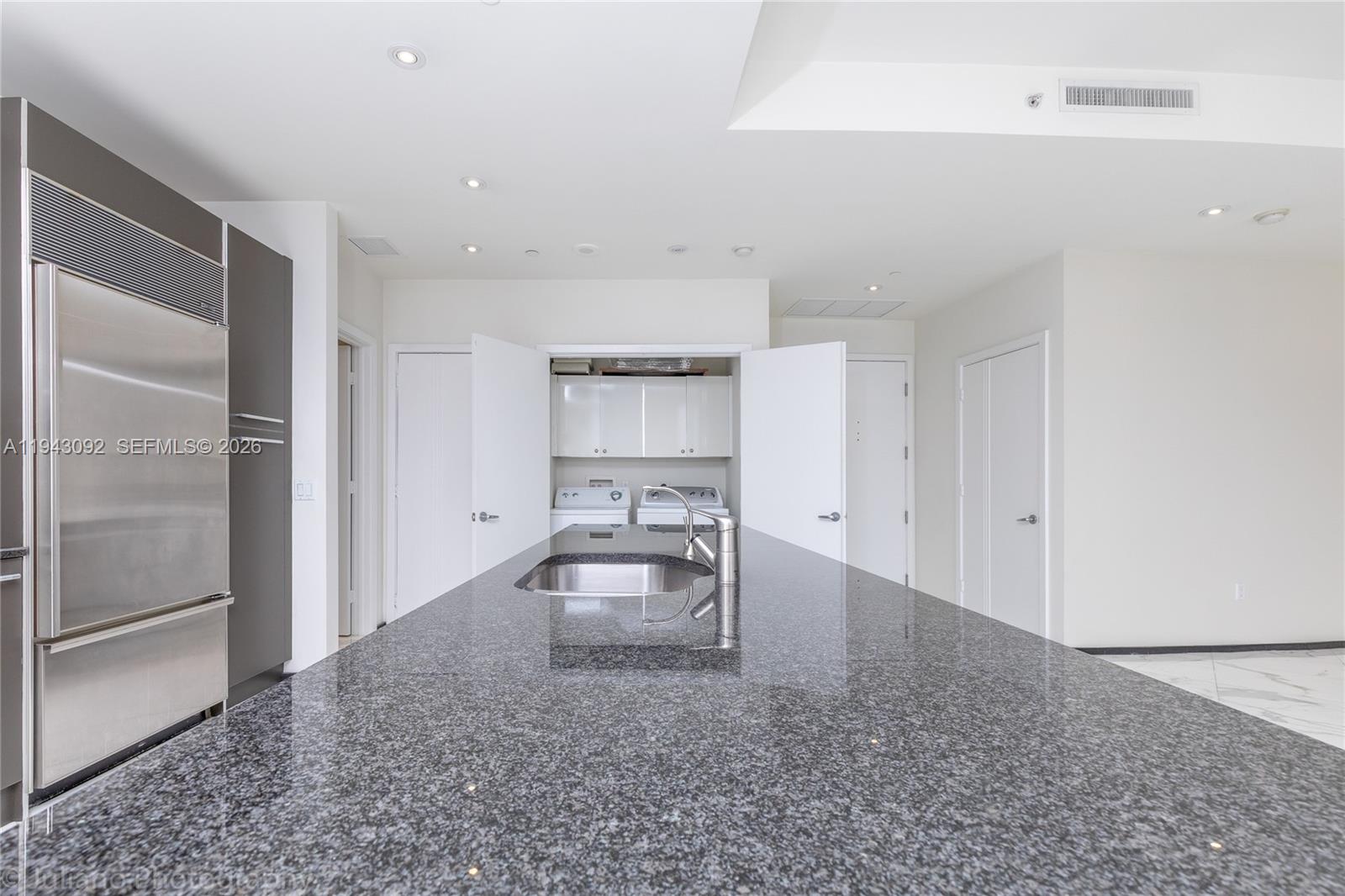 901 Brickell Key Boulevard, Unit 3407 Miami, FL 33131 - Photo 8 of 44 a large white kitchen with a sink and refrigerator