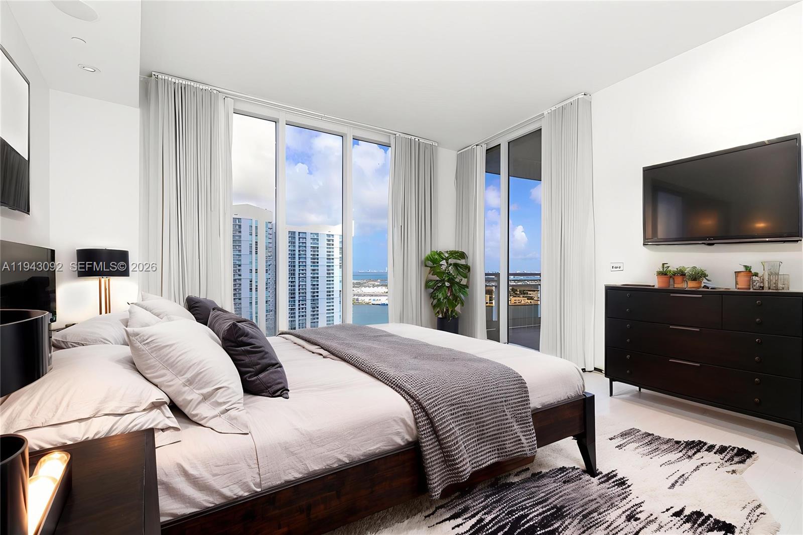 901 Brickell Key Boulevard, Unit 3407 Miami, FL 33131 - Photo 10 of 44 a bedroom with a bed and a flat screen tv
