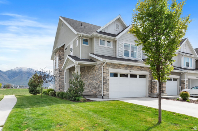 2343 Wysteria Drive Mapleton, UT 84664 - Photo 2 of 30 Craftsman-style home with an attached garage, a mountain view, stone siding, concrete driveway, and a front lawn