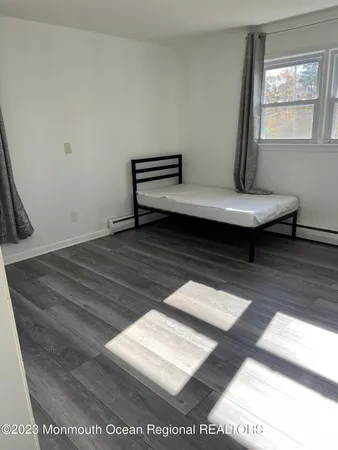 a view of a room with wooden floor and window