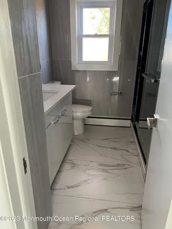 a bathroom with a sink toilet and window