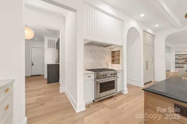 a large kitchen with stainless steel appliances a large counter top a sink and a window