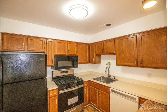 a kitchen with stainless steel appliances granite countertop a stove a sink and a refrigerator