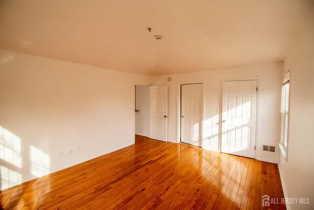 a view of an empty room and wooden floor