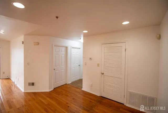 a view of an empty room with wooden floor