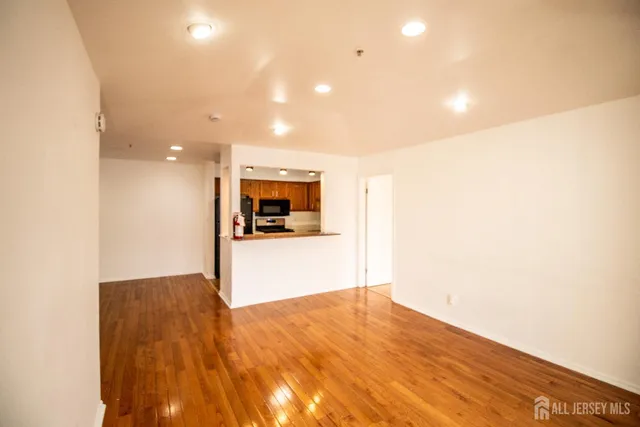 a view of empty room with wooden floor
