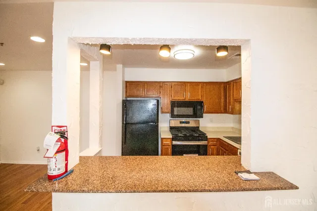 a kitchen with a refrigerator and a stove top oven