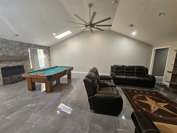 a living room with furniture a fireplace and a ceiling fan