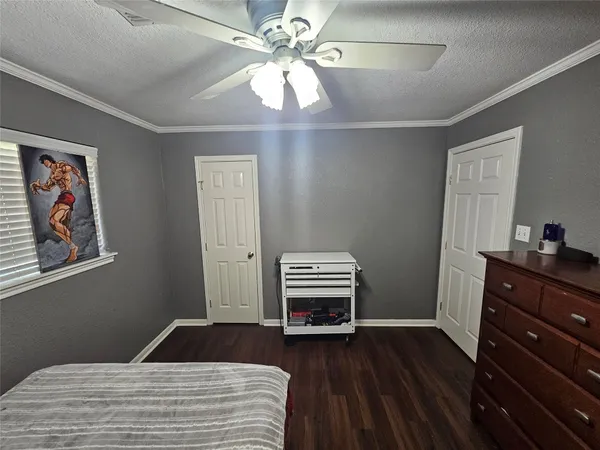 a view of a hallway with wooden floor and a kitchen
