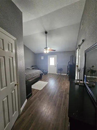 a bedroom with bed and wooden floor