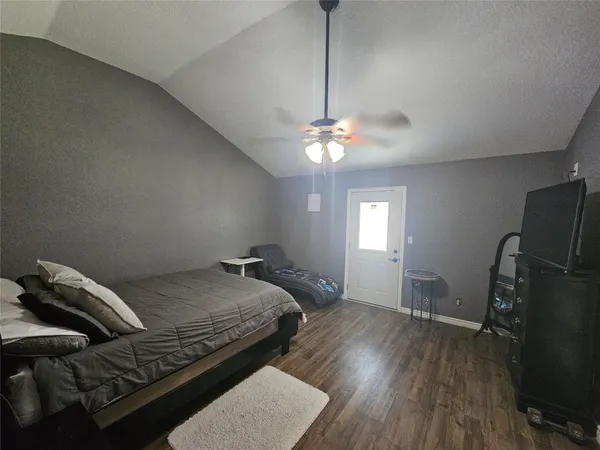 a bedroom with bed and wooden floor
