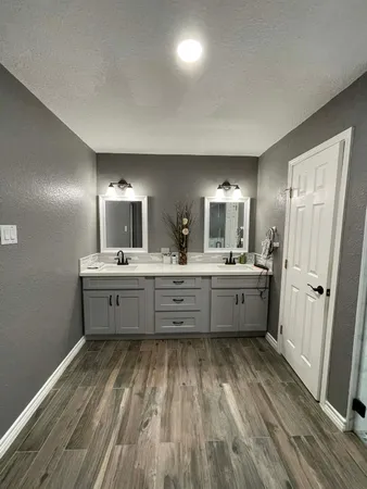 a spacious bathroom with a granite countertop sink a toilet and mirror