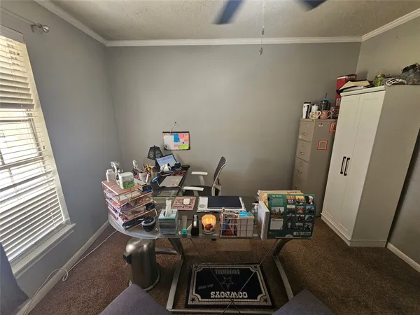 a view of a workspace with furniture and a window