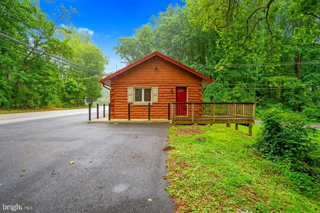a view of a house with a yard and large tree