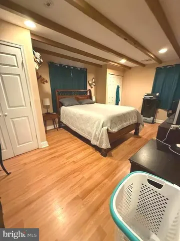 a bedroom with a bed and a flat tv screen on a dresser