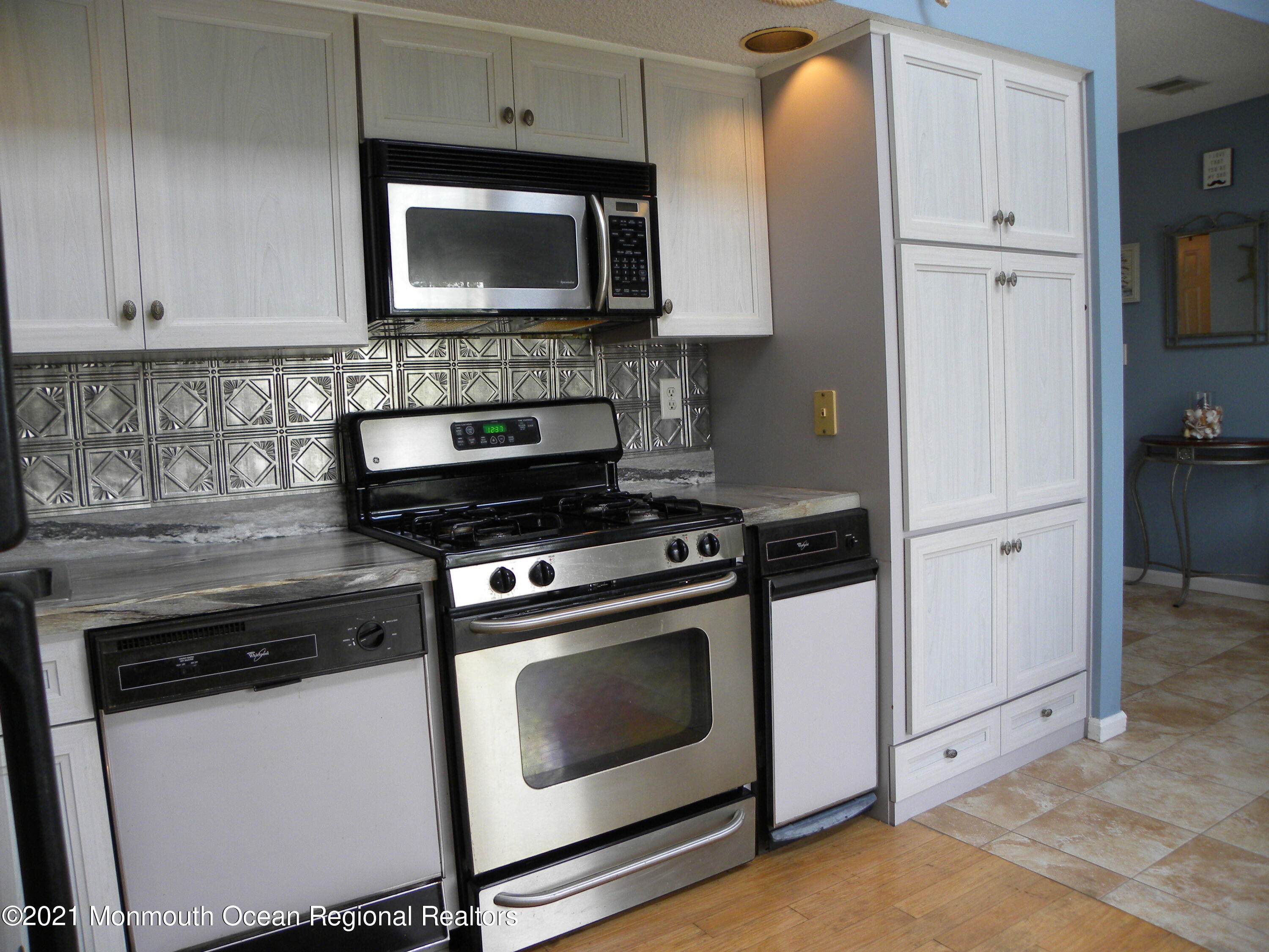 337 Lacey Road, Unit 37 Forked River, NJ 08731 - Photo 8 of 34 a kitchen with granite countertop white cabinets and stainless steel appliances