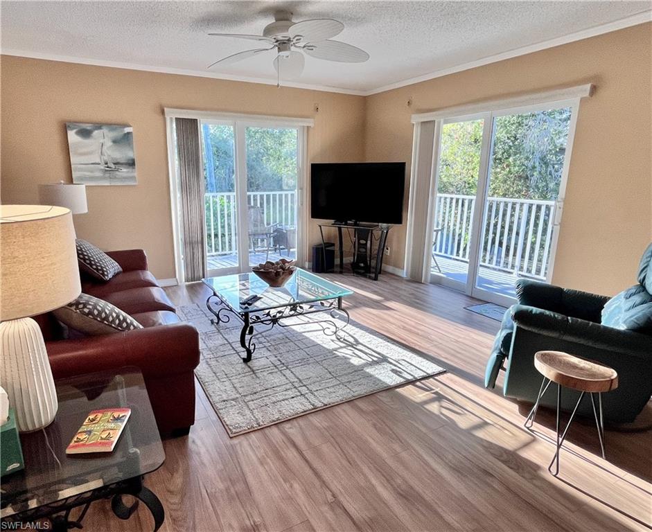 a living room with furniture a flat screen tv and a large window