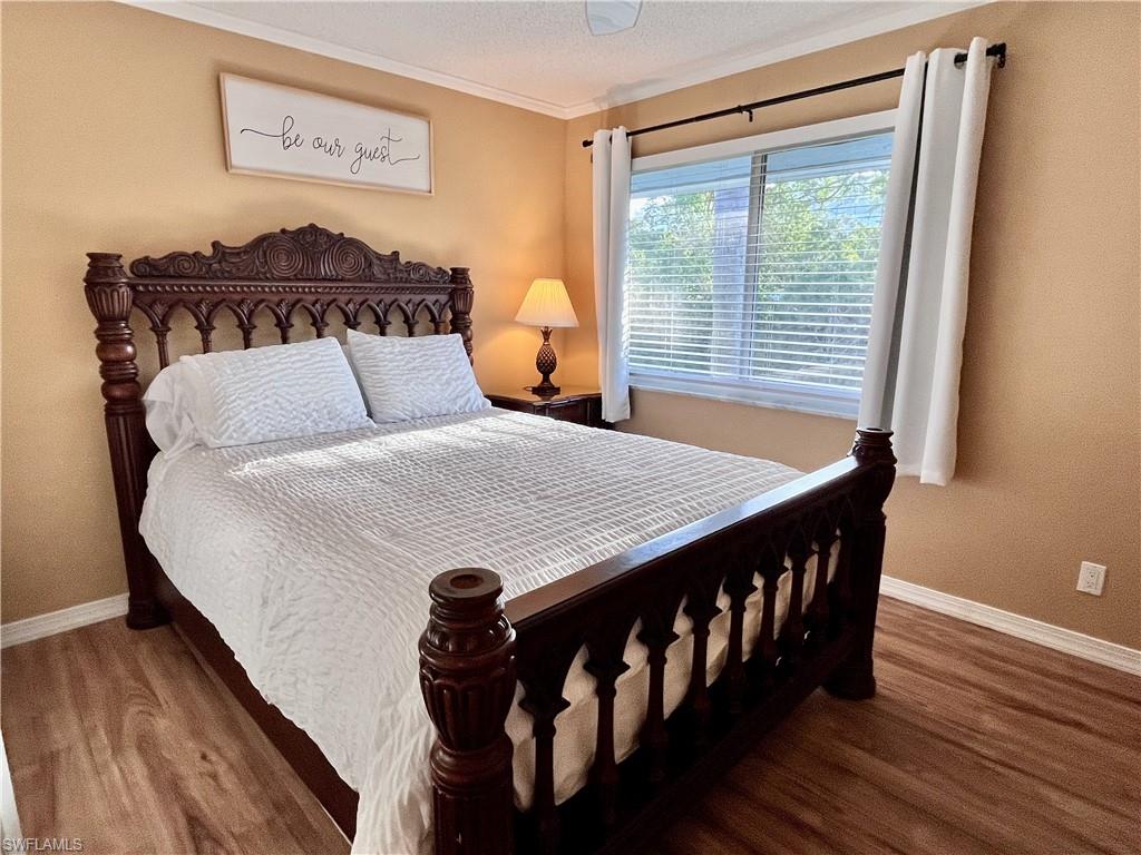 256 Palm Drive, Unit 6 Naples, FL 34112 - Photo 13 of 27 a bedroom with a bed and wooden floor