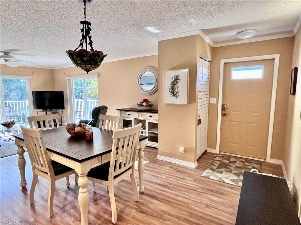 256 Palm Drive, Unit 6 Naples, FL 34112 - Photo 3 of 27 a view of a dining room with furniture and wooden floor