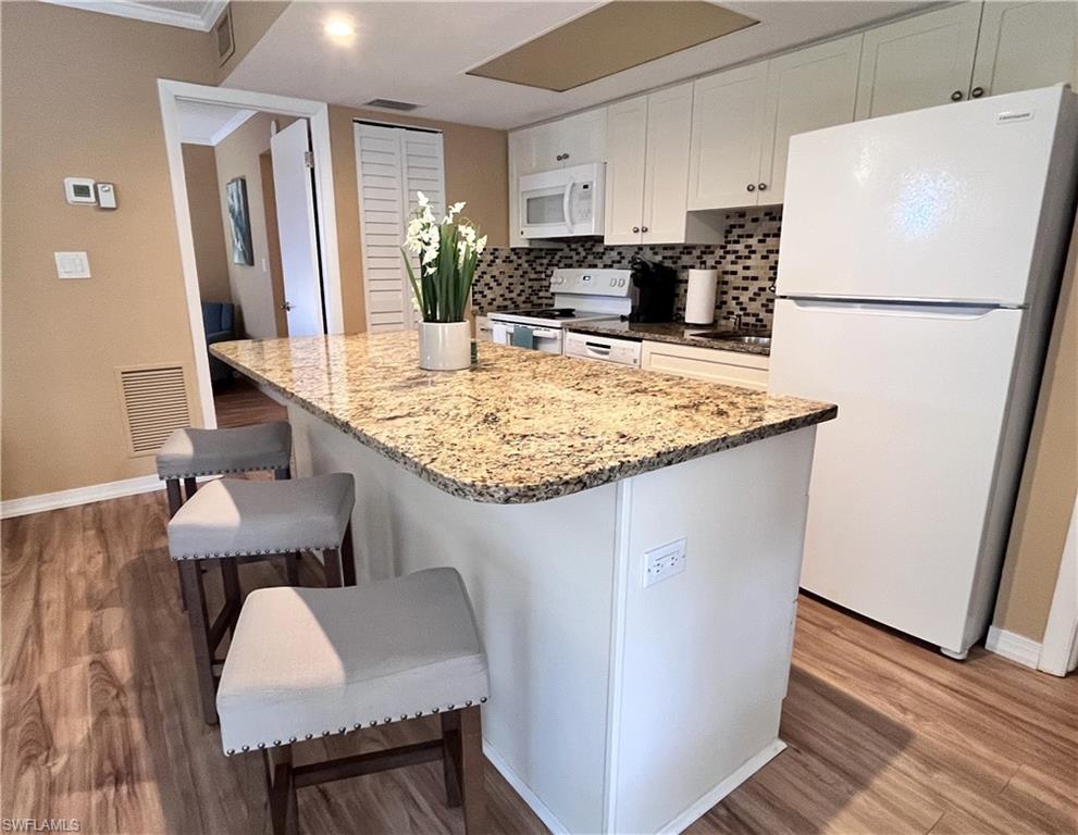 256 Palm Drive, Unit 6 Naples, FL 34112 - Photo 5 of 27 a kitchen with sink cabinets and wooden floor