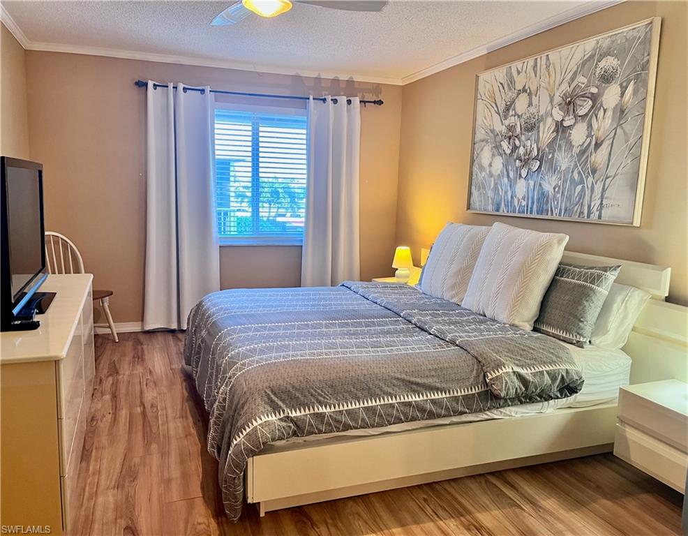256 Palm Drive, Unit 6 Naples, FL 34112 - Photo 7 of 27 a bedroom with a bed and wooden floor